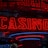 Neon lights display the word 'CASINO' in bright red, standing out against a dark background. The vibrant glow reflects a lively and bustling atmosphere.